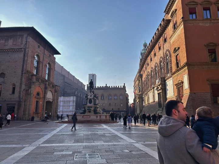 Fuente de Neptuno en Piazza Maggiore, Bolonia, con turistas y niños